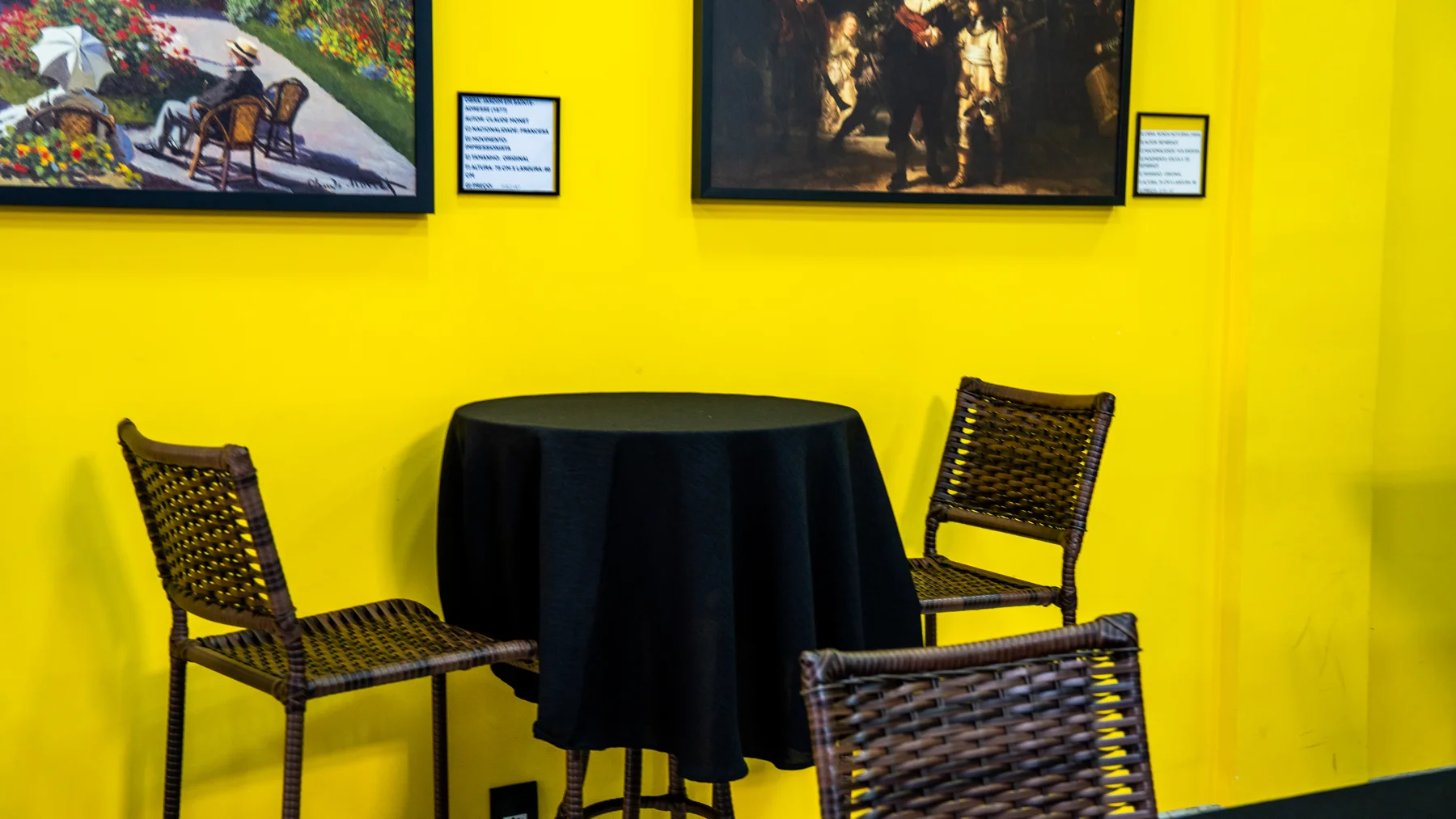 Mesa do café com quadros ao fundo
